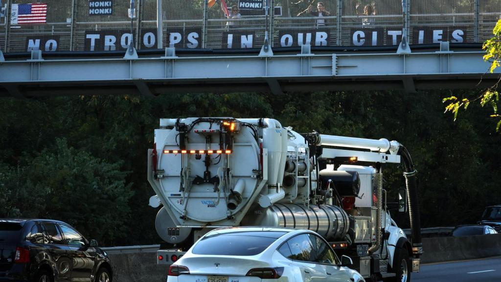 Activistas colocan un cartel que dice No hay tropas en nuestras ciudades  en un paso elevado en Nueva York.
