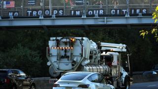 Activistas colocan un cartel que dice No hay tropas en nuestras ciudades  en un paso elevado en Nueva York.