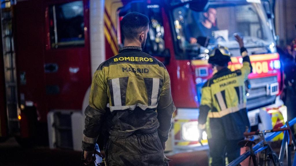 Varios bomberos durante los trabajos de esta noche en las inmediaciones del edificio derrumbado.