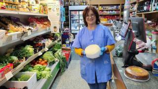 Gabriela Esmorís, propietaria del ultramarinos Gabriela, con uno de sus sabrosos quesos del país.