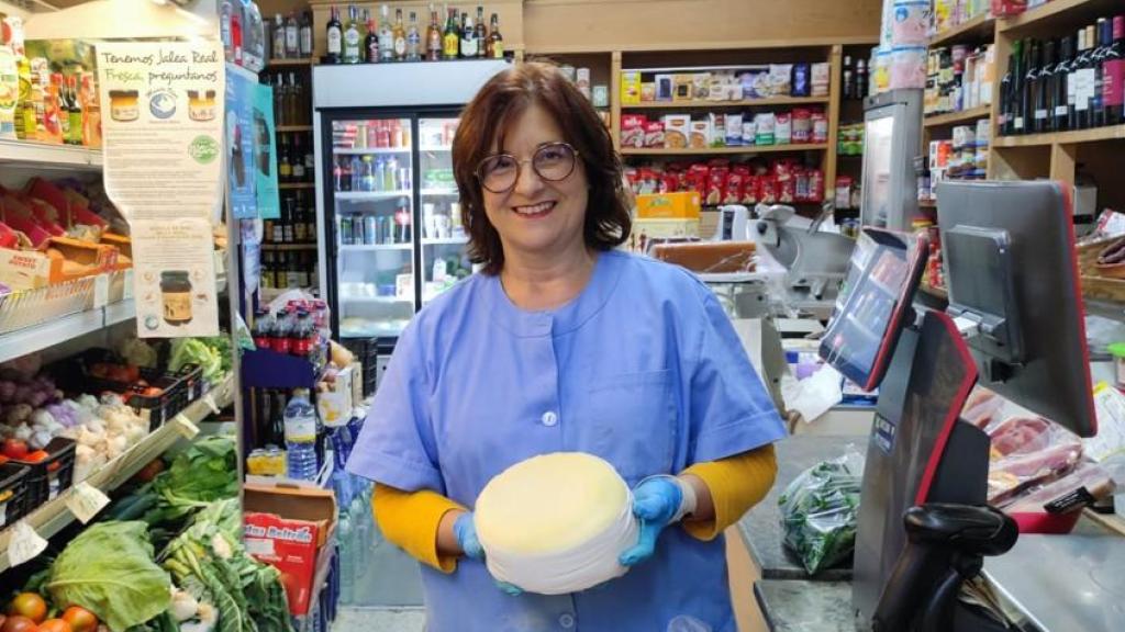 Gabriela Esmorís, propietaria del ultramarinos Gabriela, con uno de sus sabrosos quesos del país.