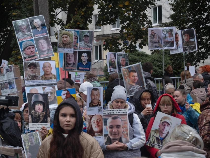 Familiares de prisioneros de guerra y desaparecidos en combate ucranianos acuden a un intercambio buscando información de sus seres queridos y mostrando sus retratos.
