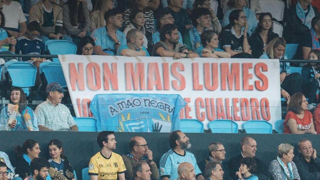 Aficionados en el partido detrás de una pancarta contra los incendios en Ourense
