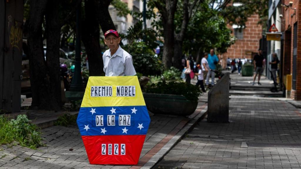 Un hombre sostiene un cartel sobre el Nobel de la Paz en Venezuela.