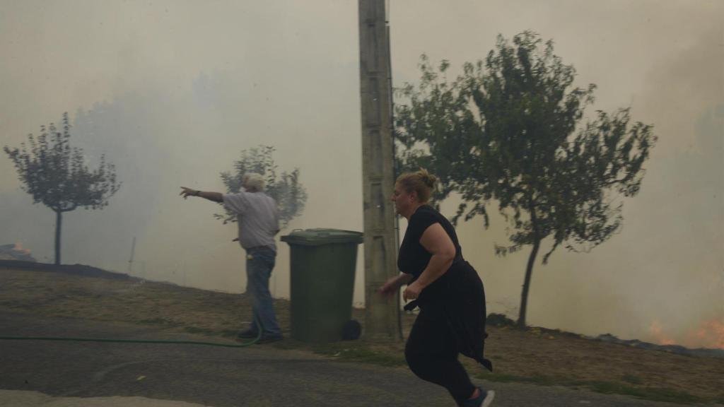 Dos vecinos colaboran en la extinción del fuego, en las proximidades de O Bolo, en Ourense.