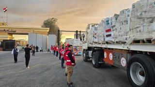 Camiones que transportan ayuda humanitaria con destino a Gaza cruzan la frontera entre Egipto y la Franja de Gaza este domingo.