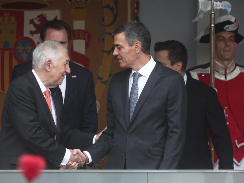 Pedro Sánchez saluda al presidente del Tribunal Constitucional, Cándido Conde Pumpido, en la tribuna de autoridades del desfile de las Fuerzas Armadas.
