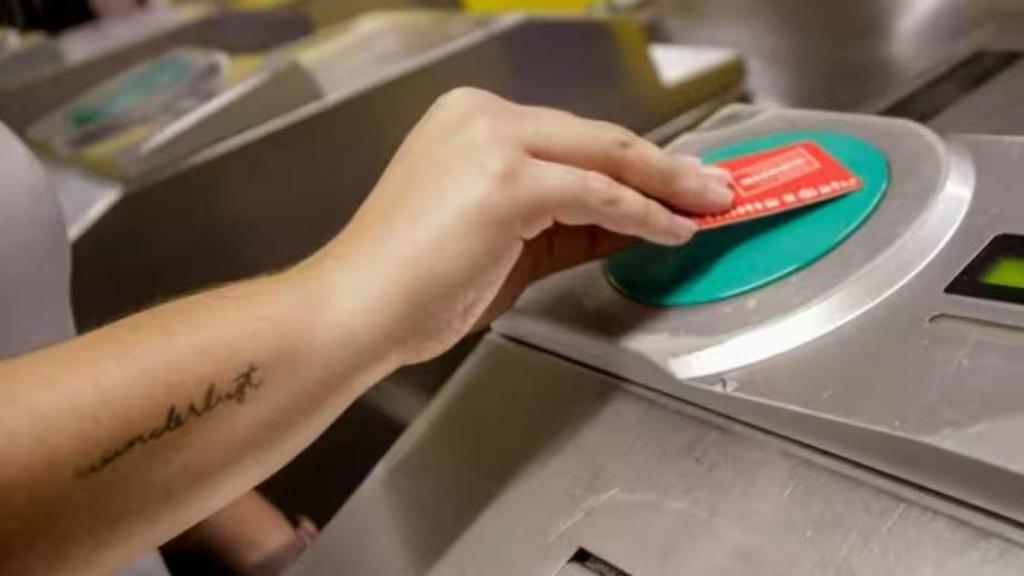 Una persona valida su abono en los tornos de entrada del metro de Ciudad Lineal, Madrid.