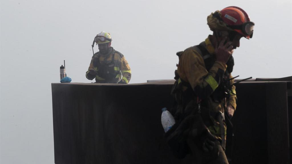 Dos brigadistas forestales observan el terreno calcinado, a 20 de septiembre de 2025, en A Barca, Sober, Lugo