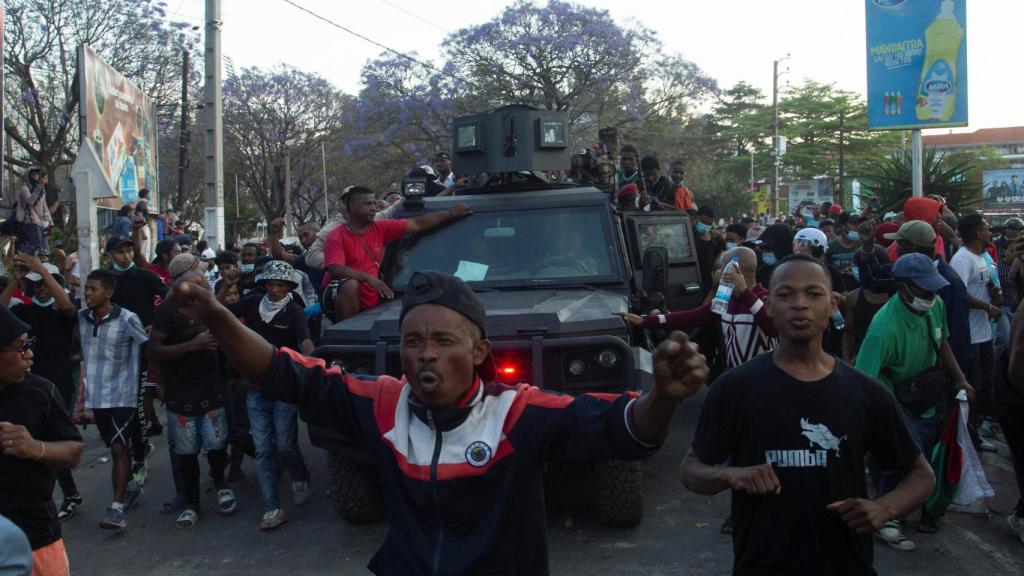 Manifestantes subidos a un vehículo blindado.