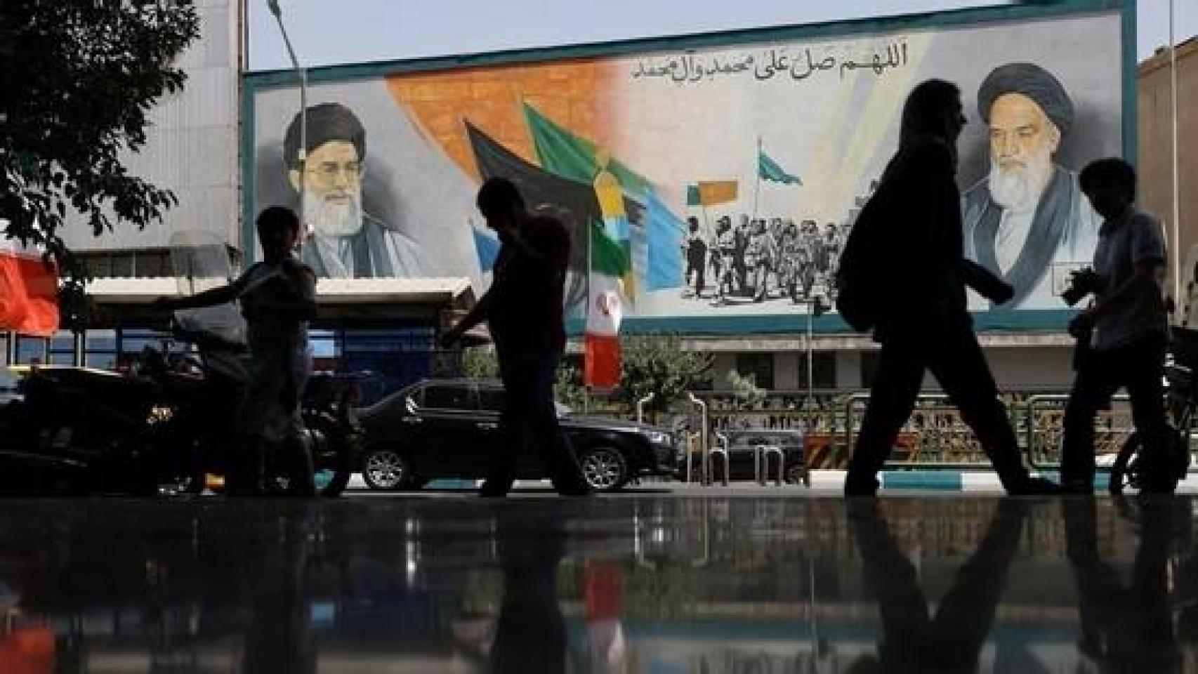 La gente camina junto a un mural con una imagen del líder supremo de Irán, el ayatolá Ali Jamenei, en una calle de Teherán.