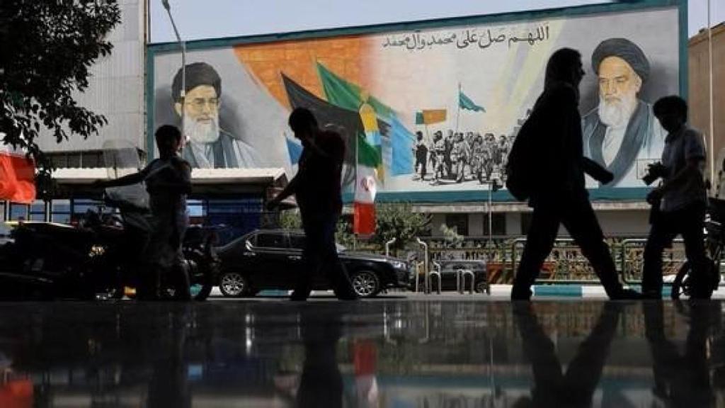La gente camina junto a un mural con una imagen del líder supremo de Irán, el ayatolá Ali Jamenei, en una calle de Teherán.