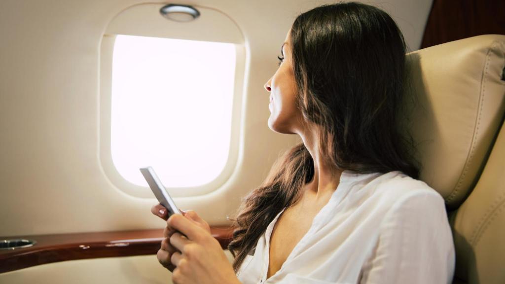 Imagen de una mujer en un avión, ilustrativa.