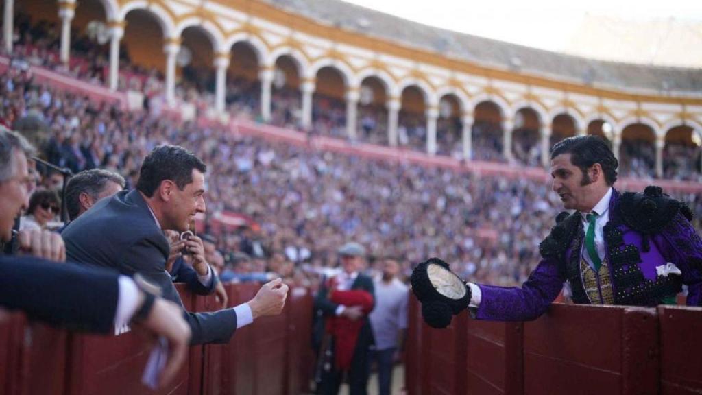 El presidente de la Junta, Juanma Moreno, recibe un brindis de Morante en la pasada Feria de Abril.