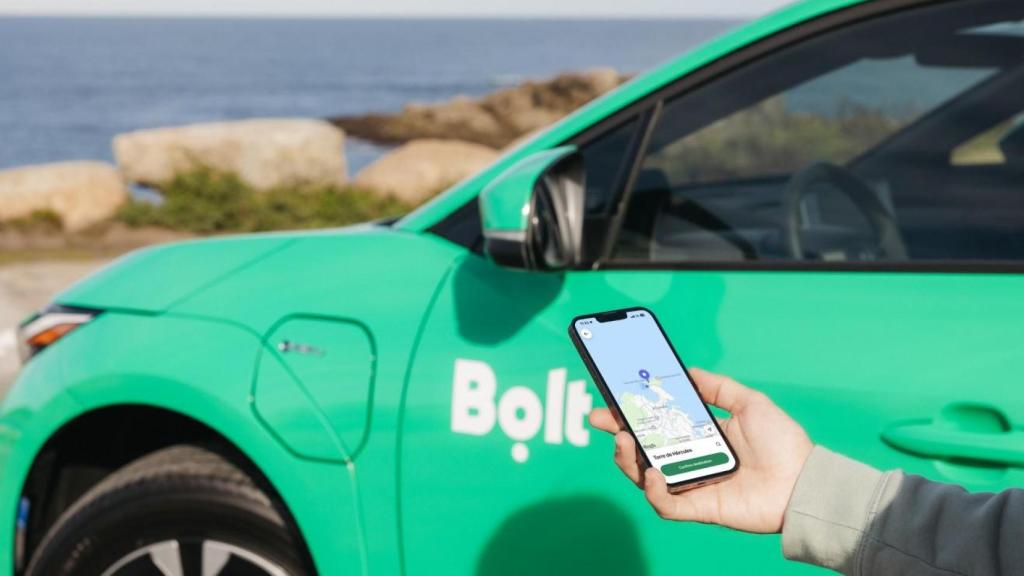 Un coche de Bolt y un móvil con la aplicación del servicio en A Coruña.