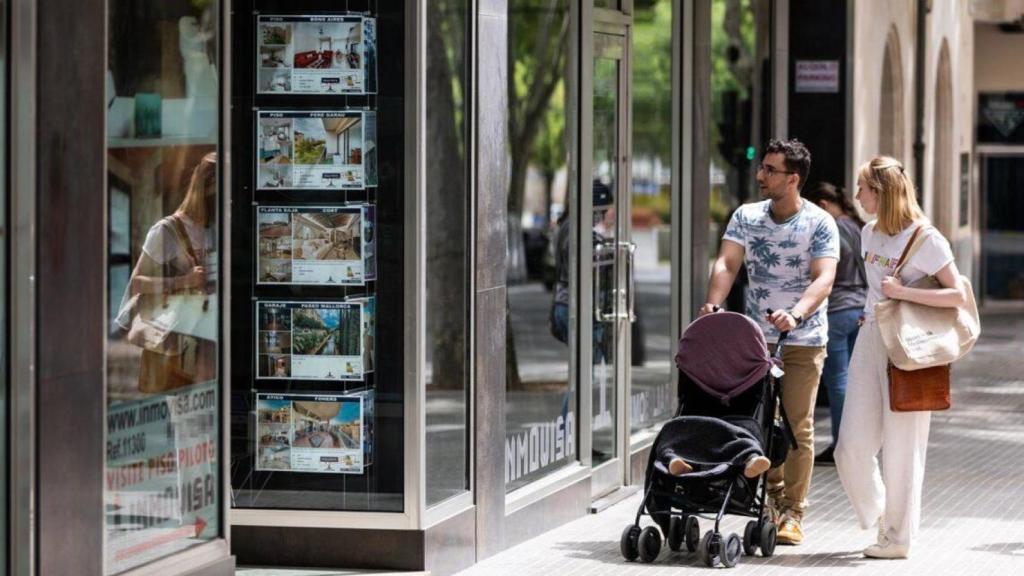 Una familia observa los anuncios de viviendas en venta en una inmobiliaria de Palma de Mallorca.