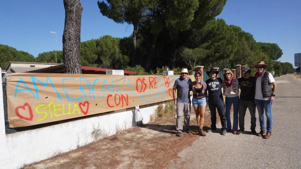 Un grupo de amigos con una pancarta de bienvenida a Stella Banderas