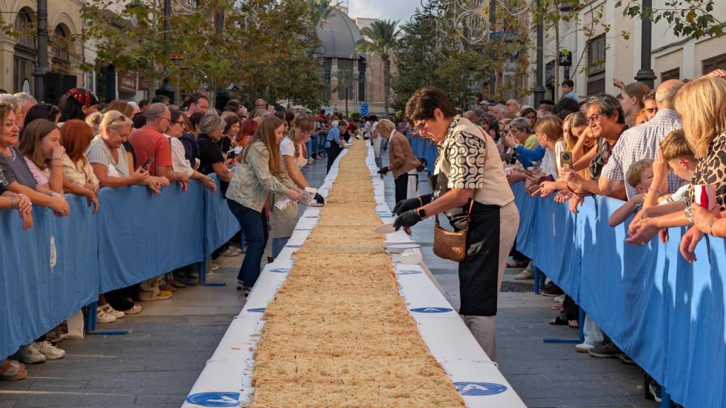 Los voluntarios cortan las raciones de la coca de mollitas este sábado en Alicante.
