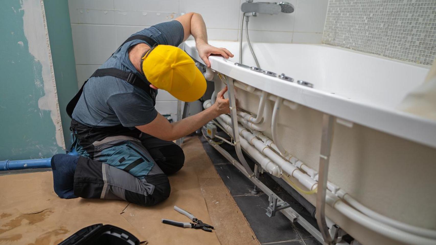 Un hombre reformando un baño.