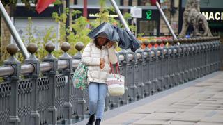 Una mujer se protege de la lluvia en León