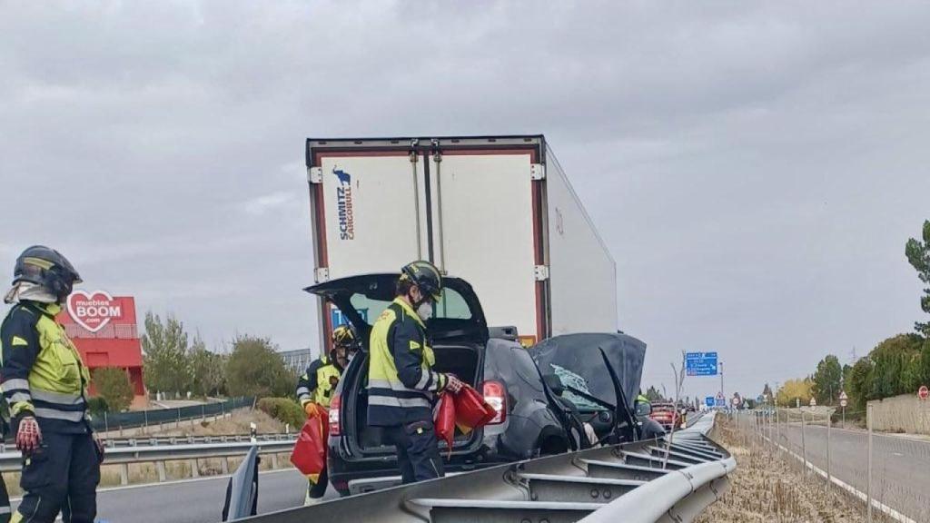 Los Bomberos en el lugar del accidente entre un camión y un vehículo