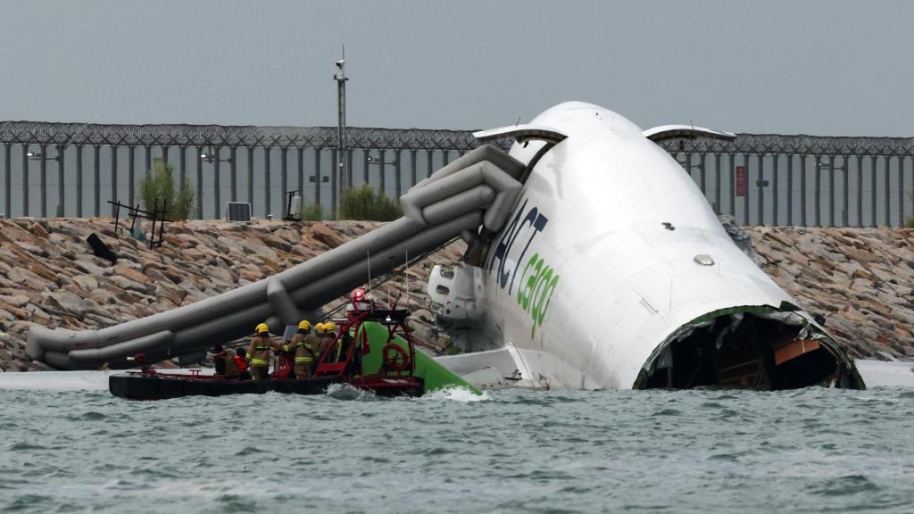 Los equipos de emergencia junto al avión accidentado.
