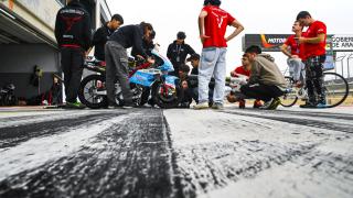 Varios ingenieros inspeccionan una moto durante la competición.