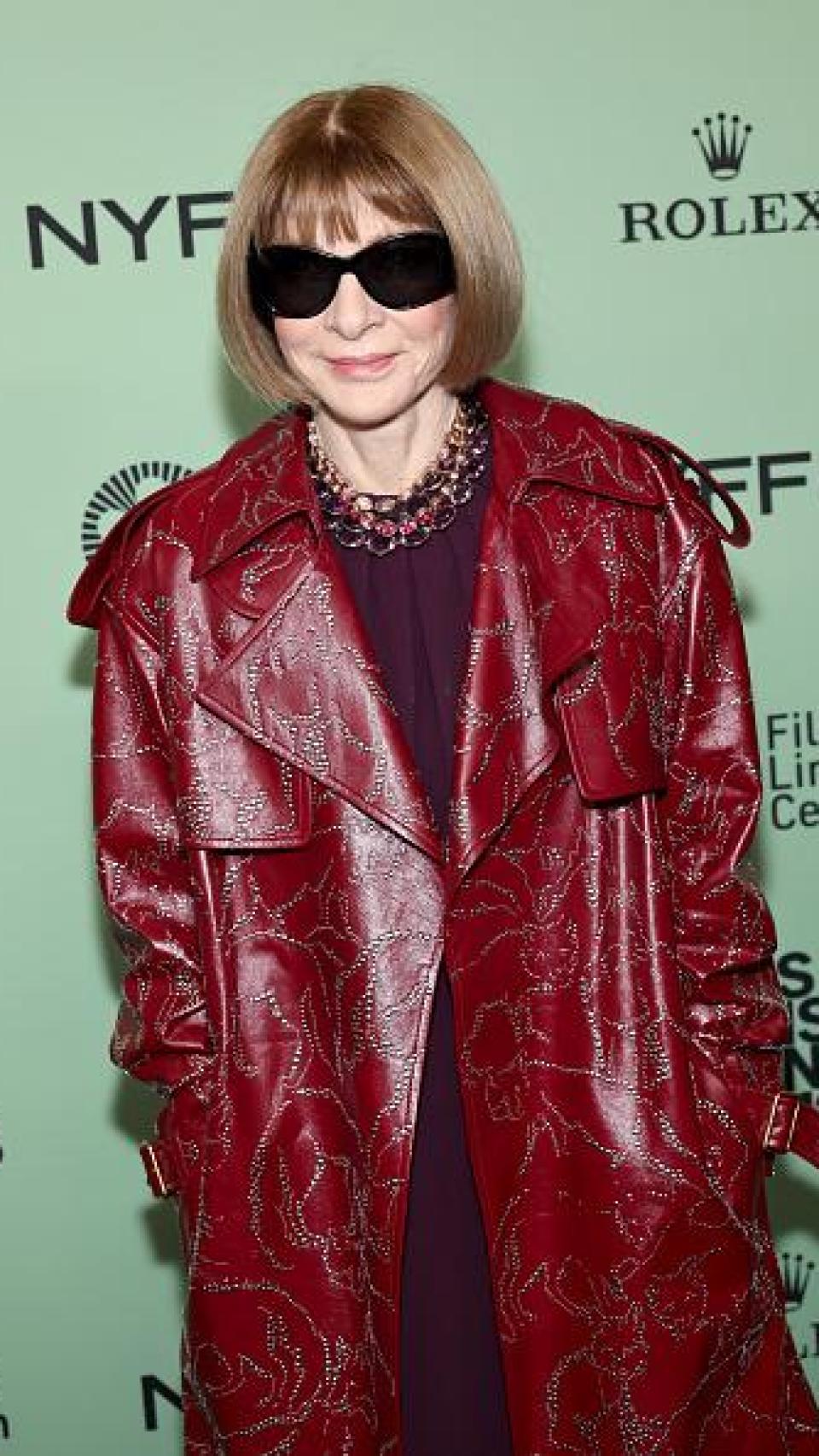 Anna Wintour luciendo una gabardina en borgoña.