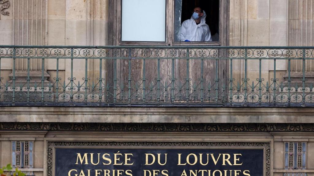 Un miembro del equipo forense inspecciona una de las ventanas que se cree que fue utilizada por los ladrones para acceder al Museo del Louvre.
