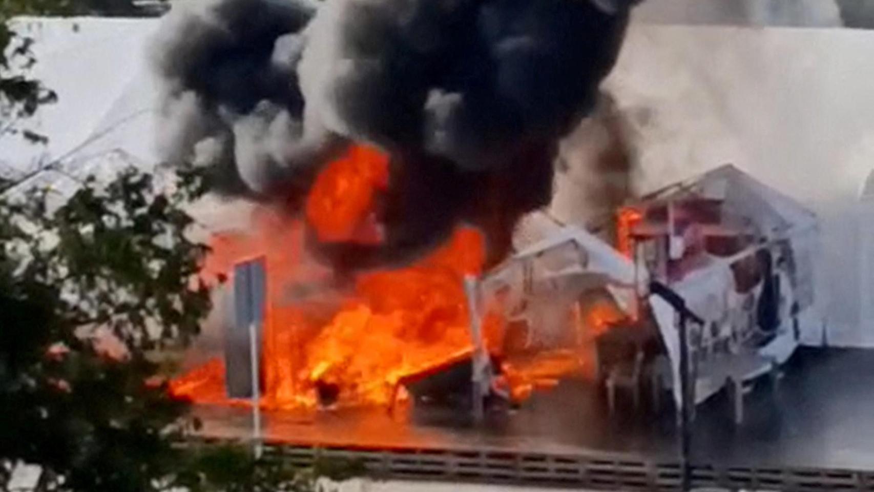 Una columna de humo sale de una carpa del campamento en apoyo a Vucic frente al Parlamento serbio durante un tiroteo este miércoles.