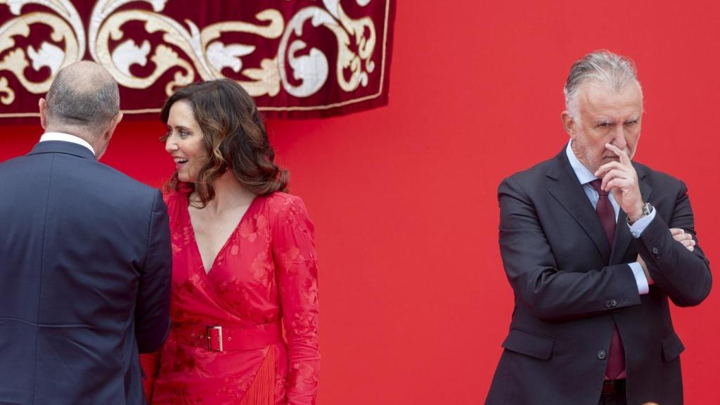 La presidenta de la Comunidad de Madrid, Isabel Díaz Ayuso, habla con el presidente del Senado, Pedro Rollán, junto al ministro de Política Territorial y Memoria Democrática, Ángel Víctor Torres,