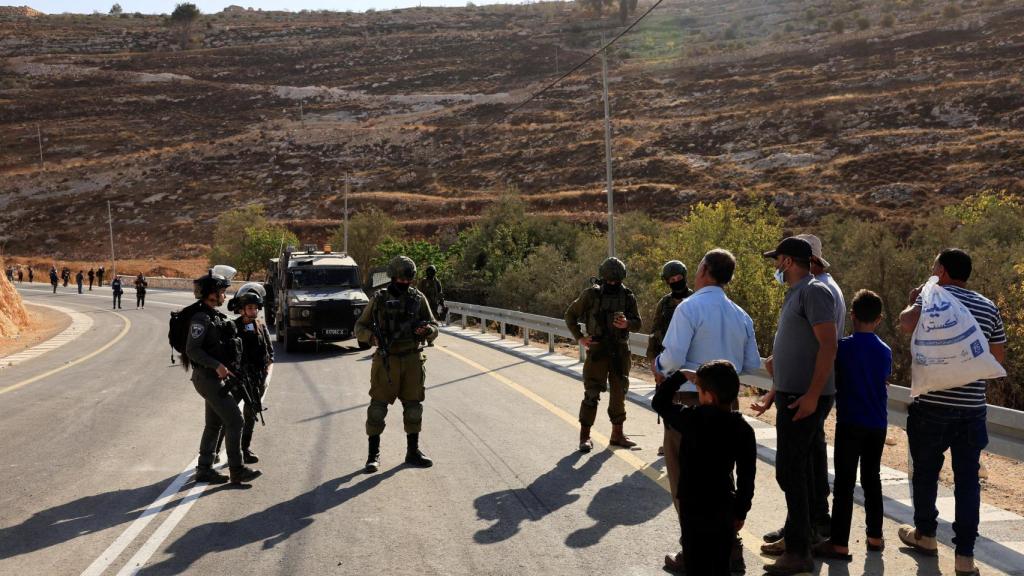 Soldados del Ejército israelí impiden a recolectores palestinos acceder a los olivares en la Cisjordania ocupada.