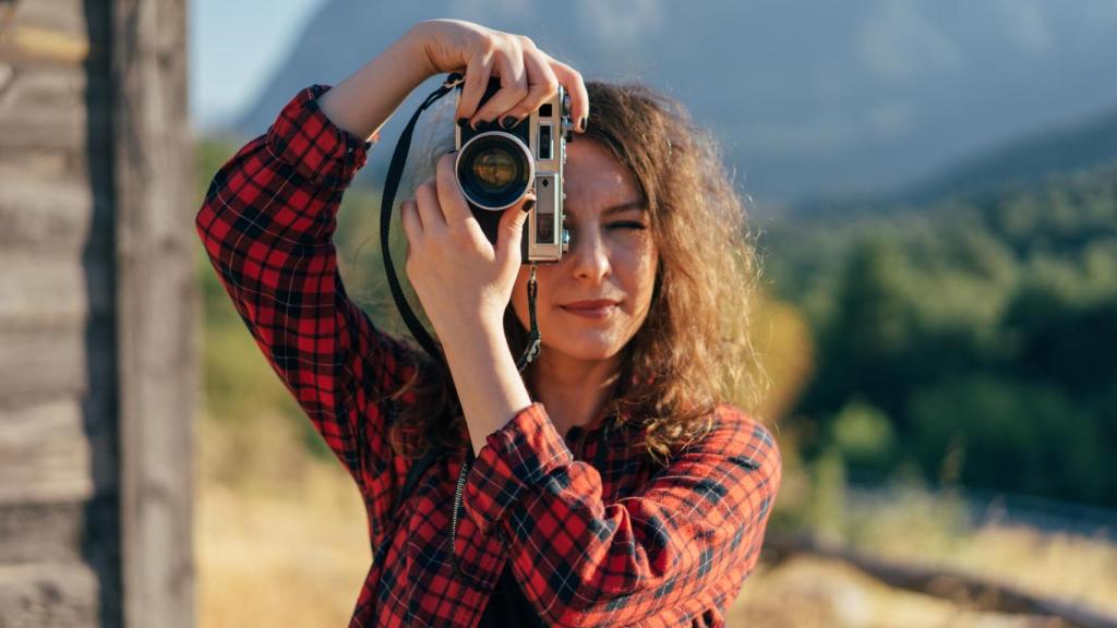 Una mujer sosteniendo una cámara de fotos.