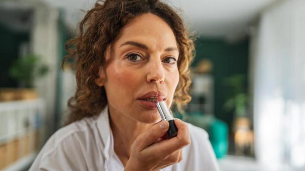 Mujer pintándose los labios.