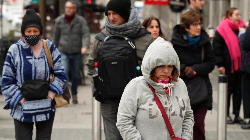 Varias personas se resguardan del frío en Madrid.