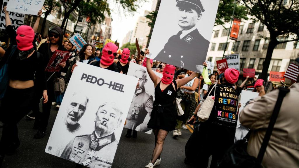Manifestantes en Nueva York portan carteles con imágenes de Donald Trump, Vladímir Putin, Benjamín Netanyahu y Jeffrey Epstein durante una protesta No Kings contra las políticas de Trump.