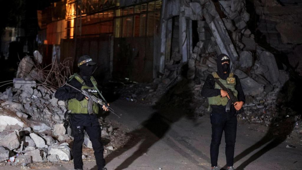 Dos milicianos de Hamas hacen guardia durante una de las entregas a la Cruz Roja de los cadáveres de rehenes israelíes.