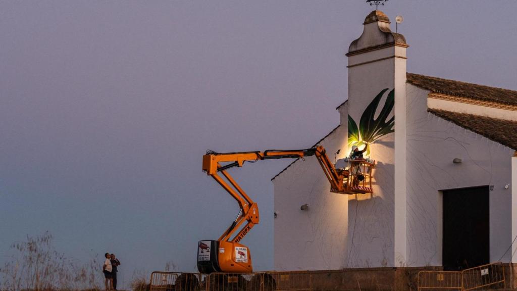El artista Manuel León en la tarea de pintar el mural a la entrada de Villanueva del Ariscal.