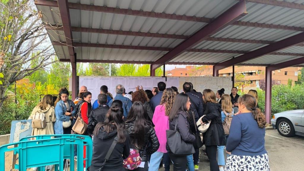 Un grupo de opositores consulta los listados de distribución de las aulas poco antes de acceder a la prueba.