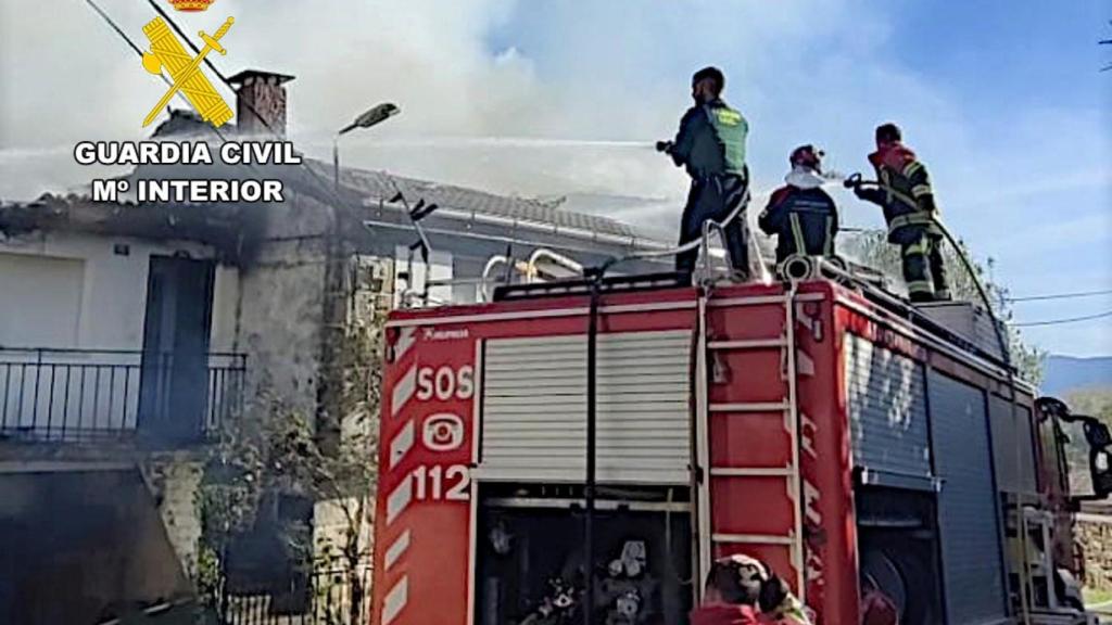 La Guardia Civil y los bomberos sofocando las llamas de la vivienda