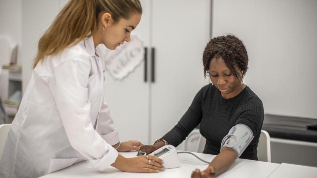 Técnicos de auxiliar de enfermería tomando la tensión a un paciente.