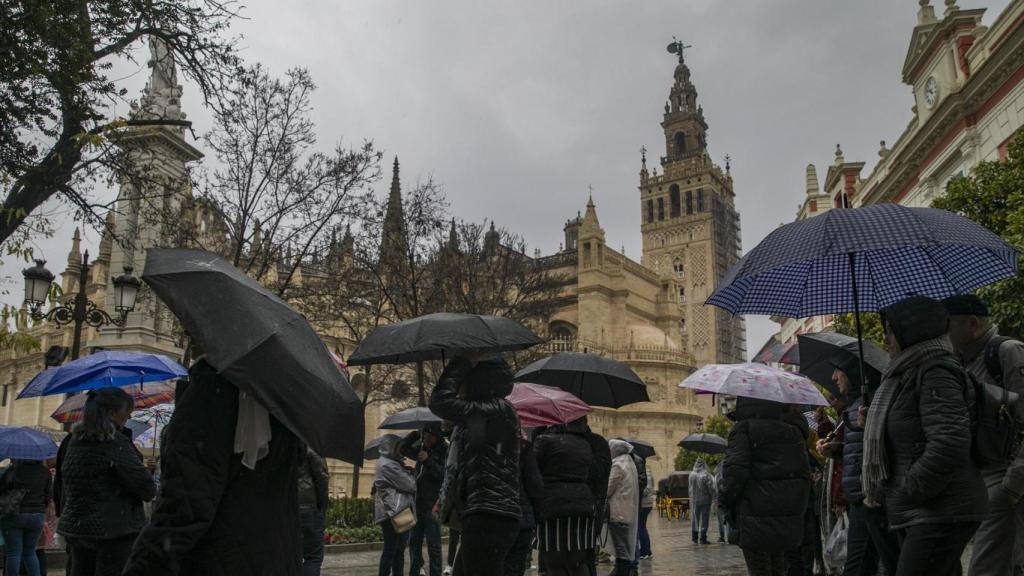 Gente con paraguas frente en la Plaza del Triunfo.
