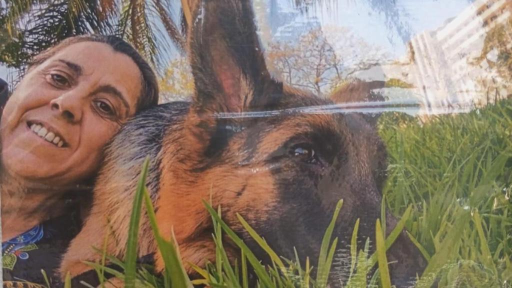 La difunta Carmen, sonriente, junto a su pastor alemán.