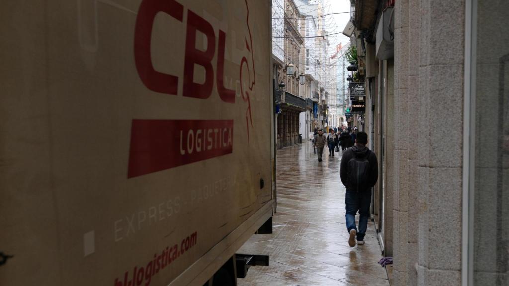 Un camión de reparto arrimado a una fachada de la calle Real.