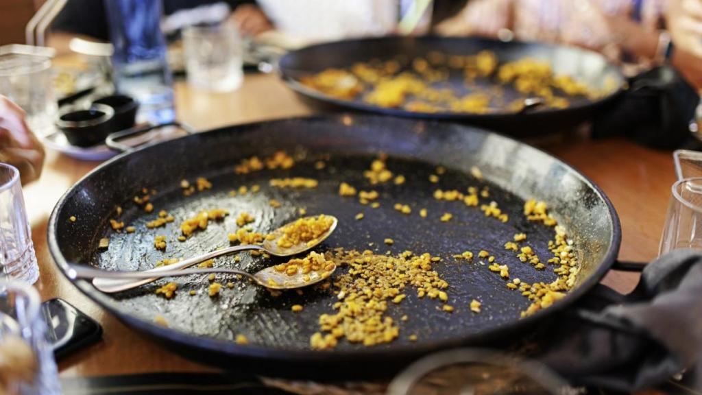 Una paella con cucharas.