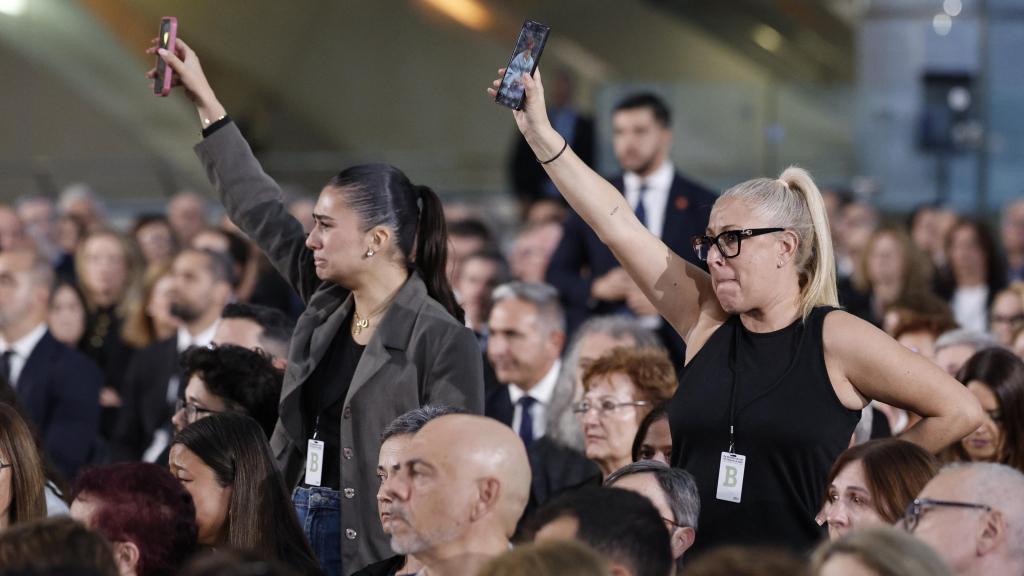 Varios de los familiares de las 237 víctimas de la dana muestran fotografías de los seres queridos fallecidos durante el funeral de Estado celebrado este miércoles en Valencia con motivo del primer aniversario de la tragedia. Efe / Kai Försterling