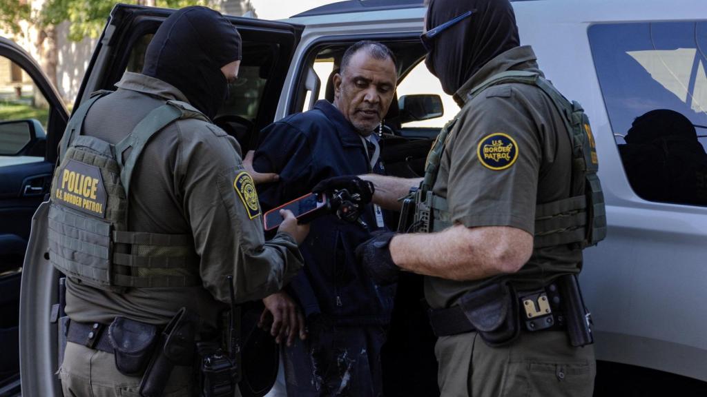 Agentes estadounidenses detienen a un hombre durante una redada migratoria en Chicago.