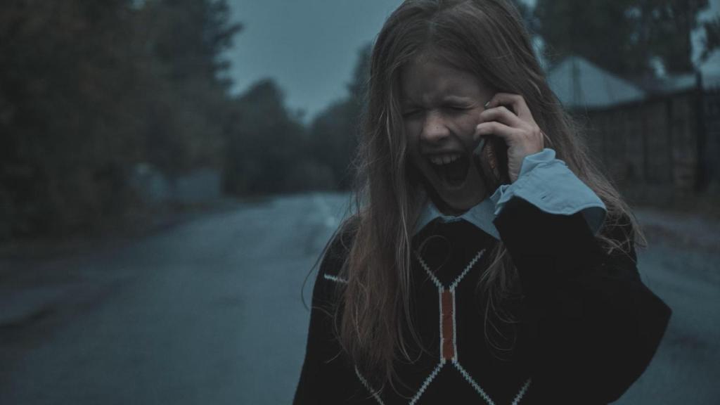 Una niña llora mientras hablar por teléfono