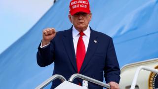 Donald Trump se despide de su gira asiática con su característica gorra.