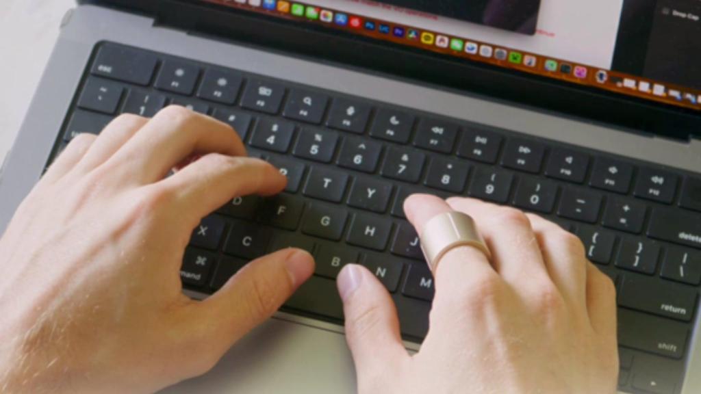 Un hombre con el anillo usando un Mac